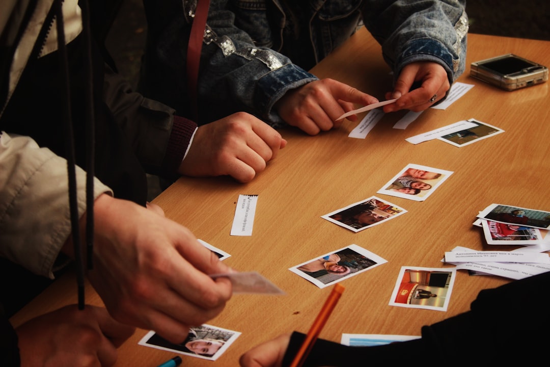 People playing a card game at a wooden table