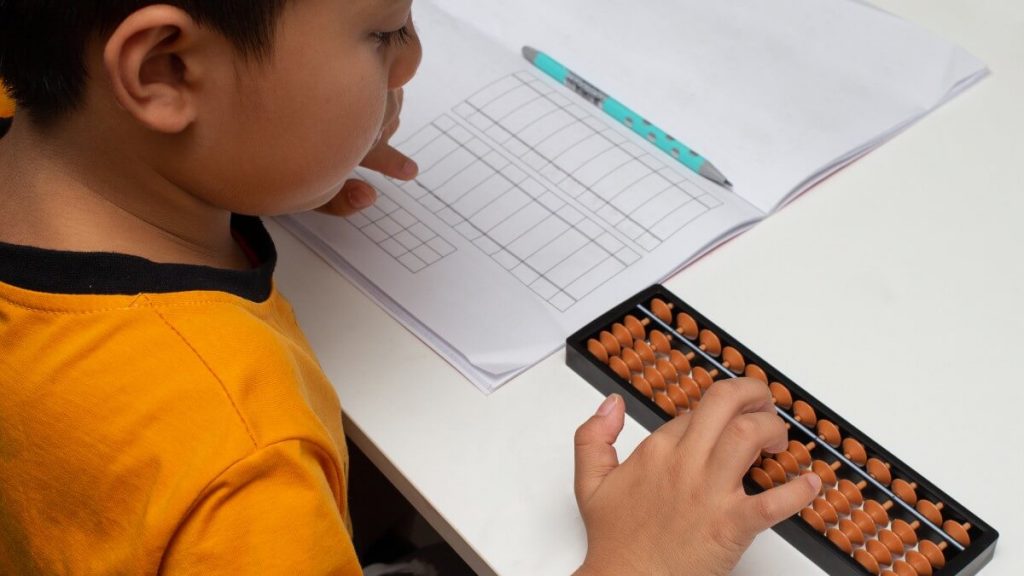 Ba châu Á ngồi cạnh con gái đang học trên máy tính bảng