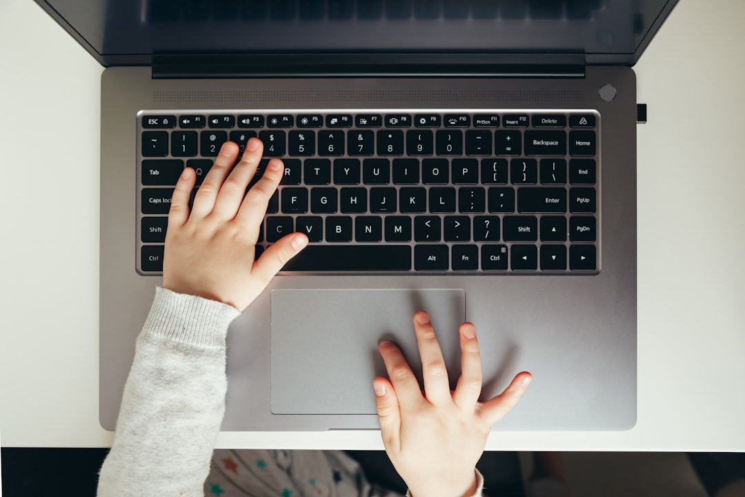 Child's hand on laptop computer keyboard. Trying to log in. Access to information, protection, and usability. Top view