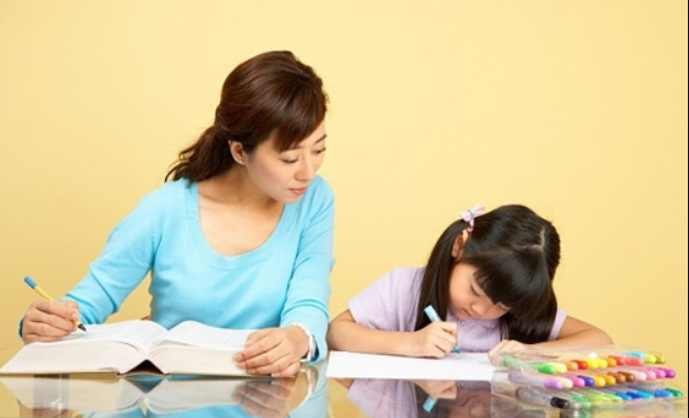 Mẹ châu Á và con gái ngồi học với vẻ căng thẳng