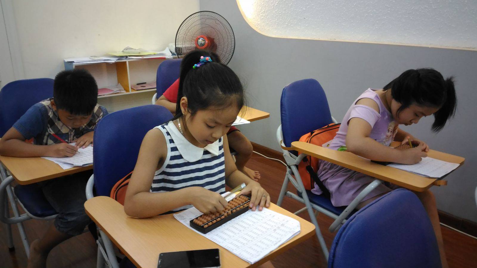 Bé trai châu Á tính nhẩm nhanh trong đầu với ánh mắt tập trung