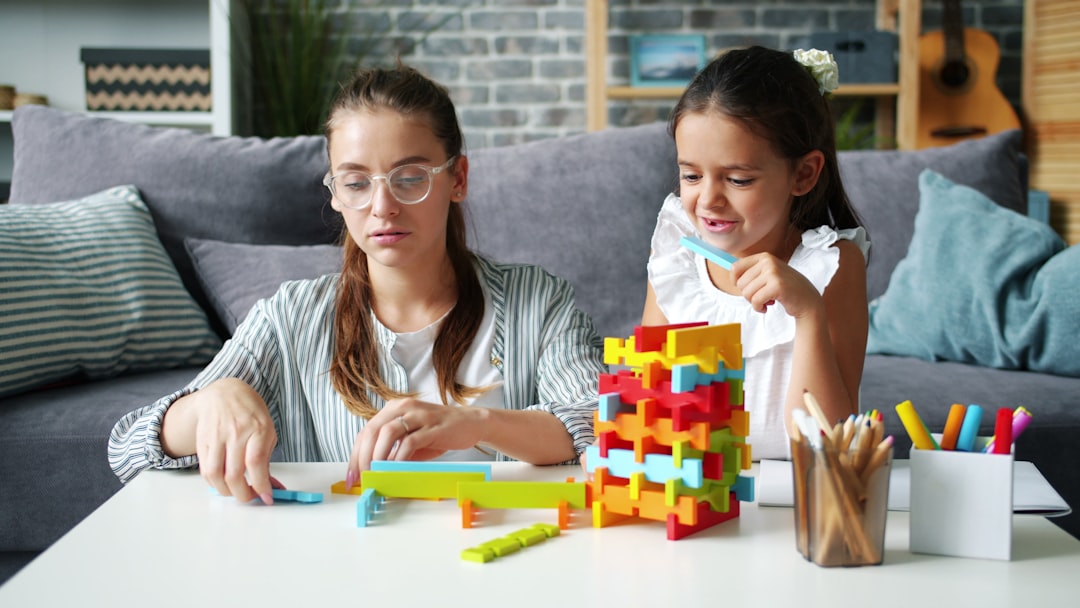 pretty woman playing blocks with cheerful daughter having fun at home bonding with child. Happiness, family activities and apartment concept.